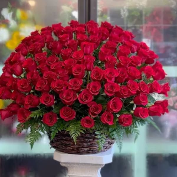 Large bouquet of red roses in a woven basket on a pedestal