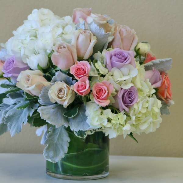 Bouquet of pastel roses and white hydrangeas in a glass vase