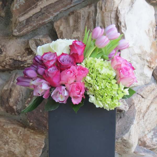 Pink and purple bouquet with roses, tulips, orchids, and hydrangea in a black box