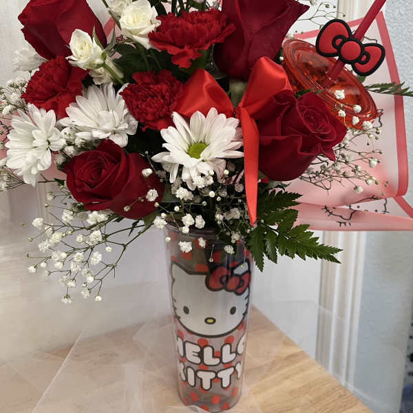 Red roses and white daisies in a Hello Kitty tumbler with a red bow.