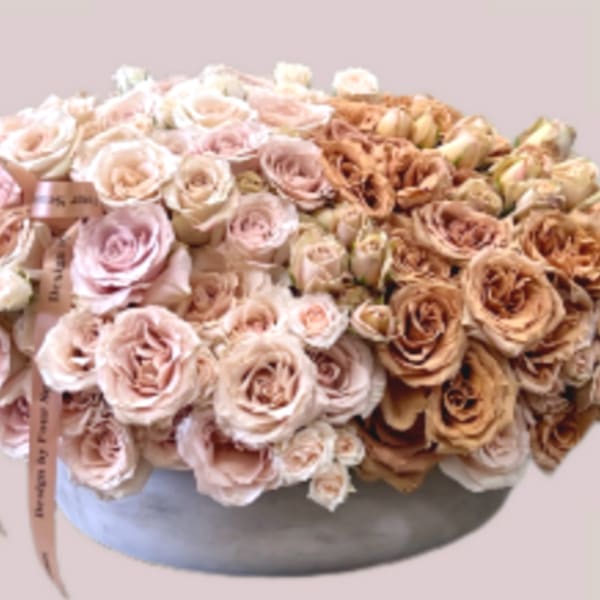Large bouquet of pale pink and tan roses in a round vase