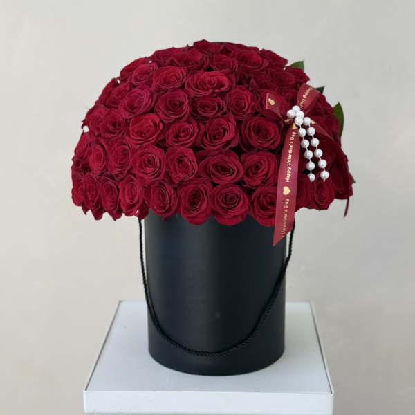 Red rose bouquet in a black hatbox with a Valentine ribbon