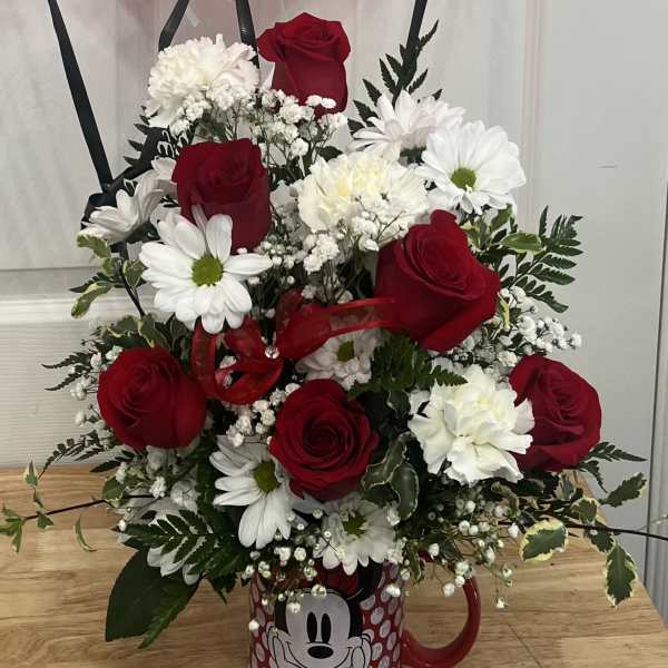 Red roses and white daisies arranged in a Mickey Mouse mug with a red balloon