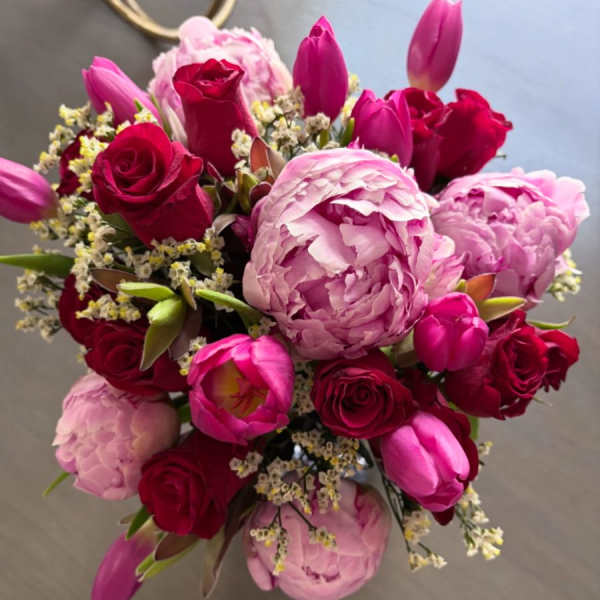 Bouquet of pink peonies, red roses, and magenta tulips