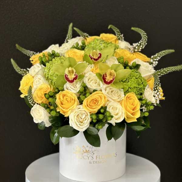 Round bouquet of yellow and white roses in a white hat box