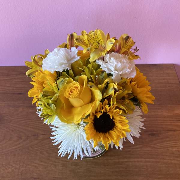 Yellow and white flower arrangement in a clear glass vase