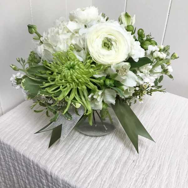 White and green floral arrangement in a glass vase