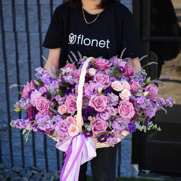 Large basket of pink and purple roses with ribbon