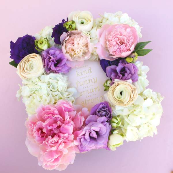 Floral wreath with pink, purple, and white blooms around a framed quote