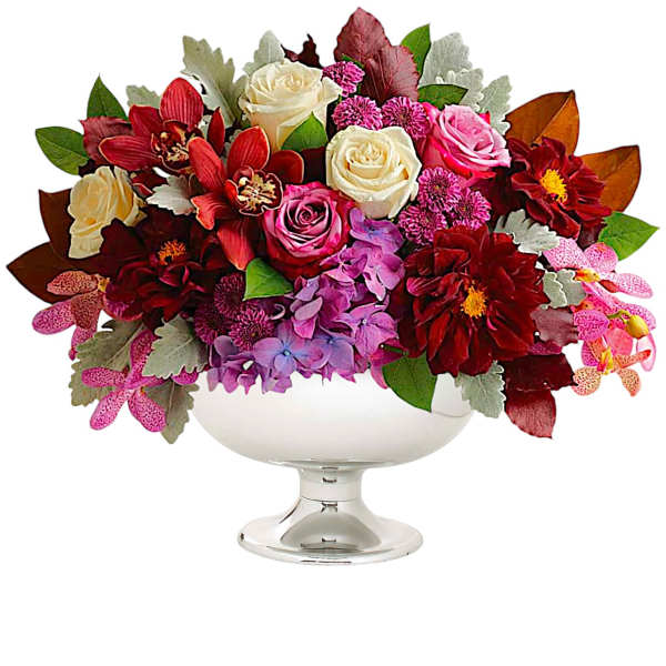 Mixed bouquet of roses and orchids in a white pedestal bowl
