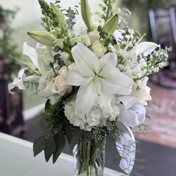 White lily and rose bouquet in a clear glass vase