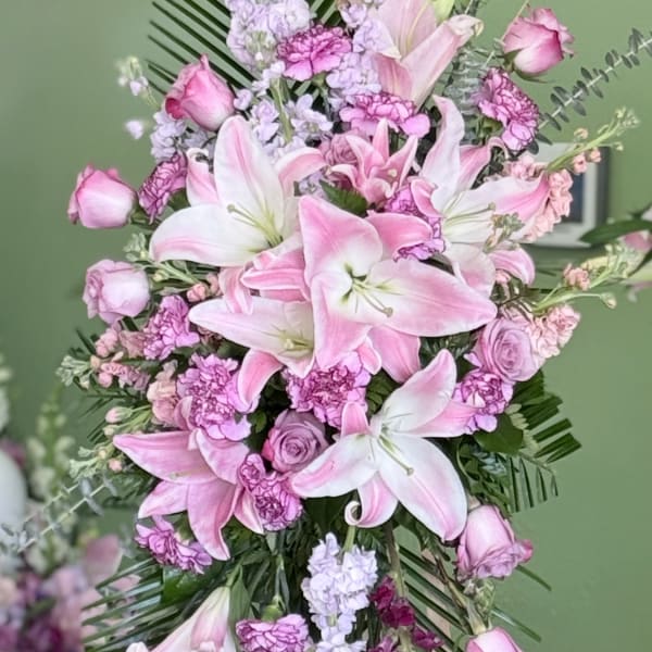 Pink lilies and roses arranged on a standing easel