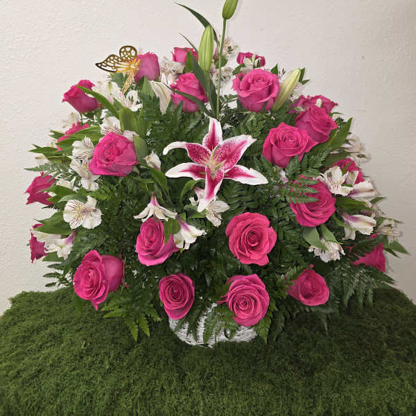 Pink roses and white lilies arranged in a white basket