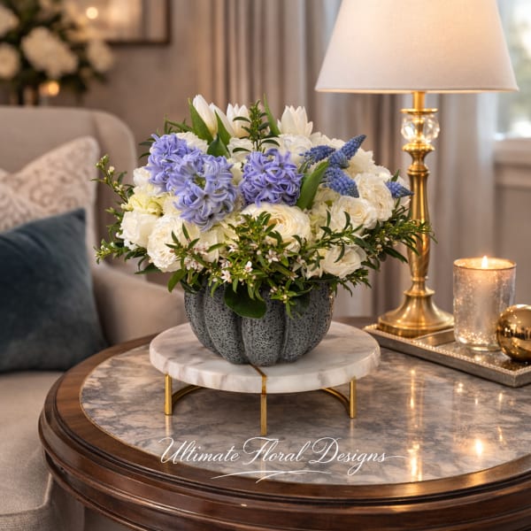 Blue and white floral arrangement in a gray vase on a table