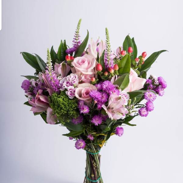Hand-tied bouquet of pink roses and purple flowers