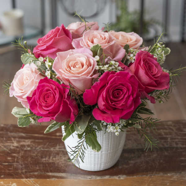Pink and blush roses arranged in a white vase