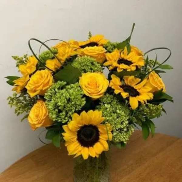 Yellow sunflowers and roses in a glass vase
