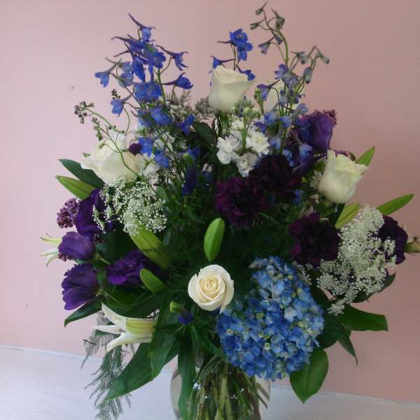 Bouquet of blue, white, and purple flowers in a glass vase