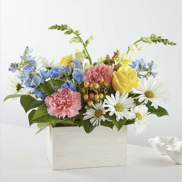 Mixed bouquet in a white box with yellow roses, pink carnations, and white daisies