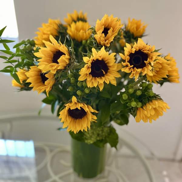 Bouquet of yellow sunflowers in a green vase