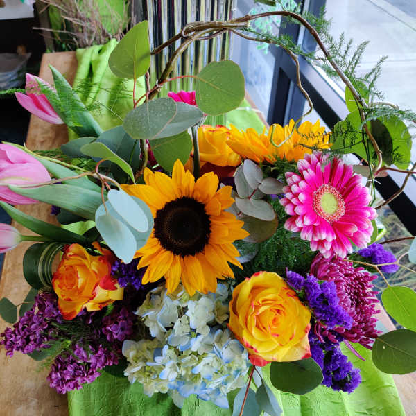 Mixed bouquet with sunflowers, pink tulips, roses, and a gerbera daisy