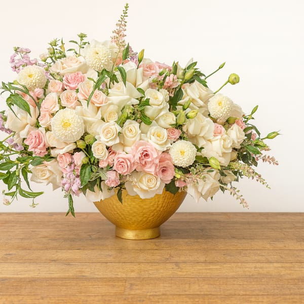 Blush and white rose arrangement in a gold bowl vase