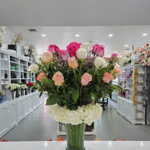 Tall bouquet of pink and white roses in a glass vase