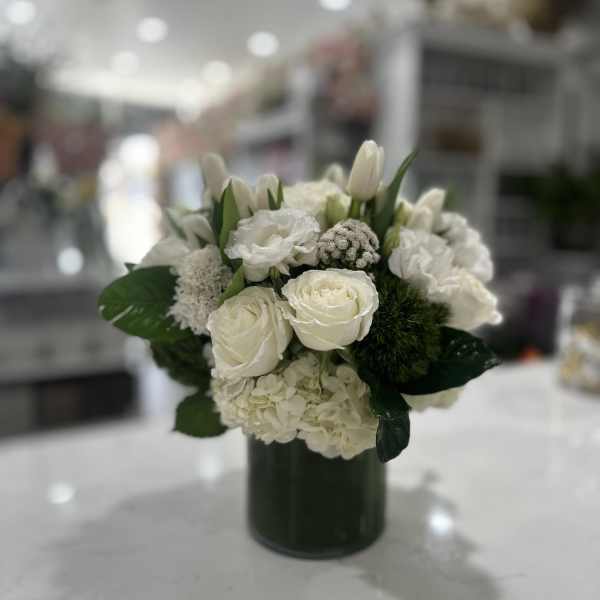 White floral arrangement in a dark green vase