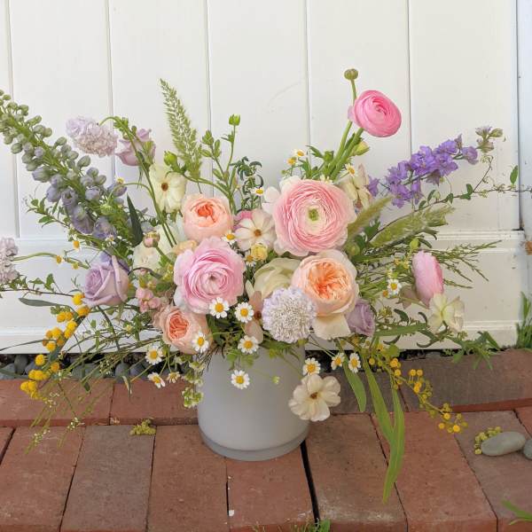 Pastel mixed flower arrangement in a white vase
