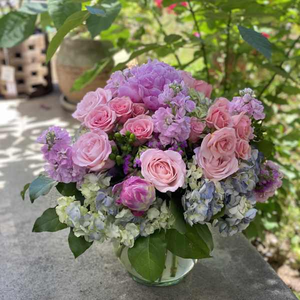 Pink roses and lavender hydrangeas in a glass vase