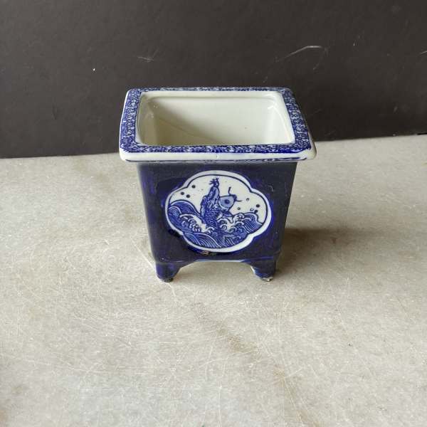 Blue-and-white ceramic square planter with a fish design