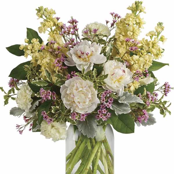 Bouquet of white peonies and yellow flowers in a clear glass vase