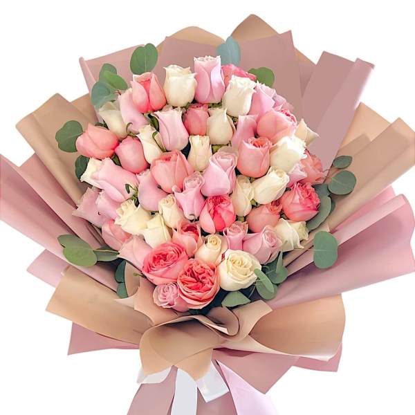 Bouquet of pink and cream roses wrapped in blush paper