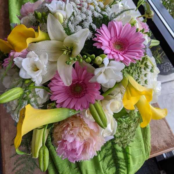 Bouquet of pink gerbera daisies, white lilies, and yellow calla lilies