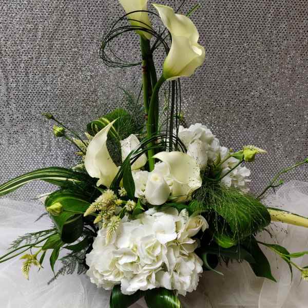Tall white floral arrangement with calla lilies and hydrangeas