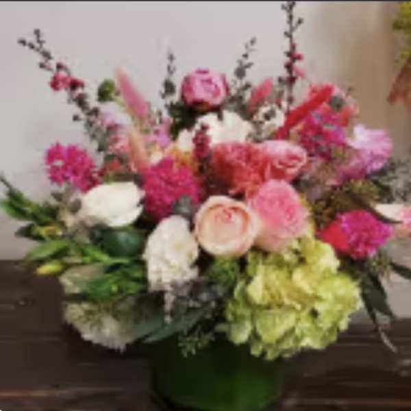 Mixed pink and white floral arrangement in a green vase