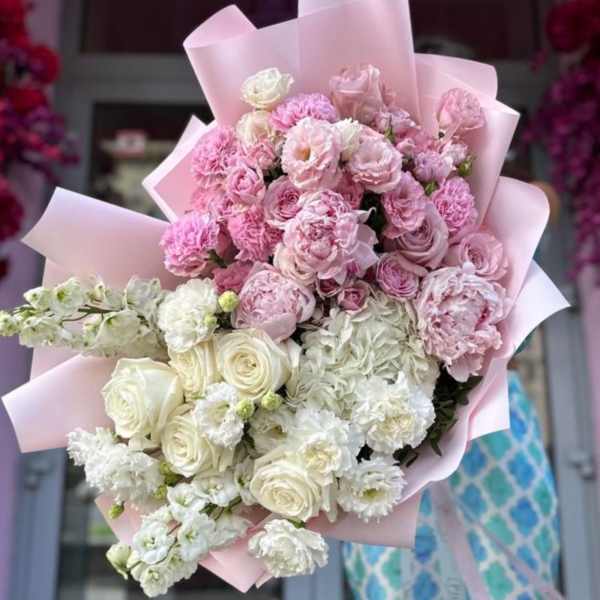 Large bouquet of pink and white roses with carnations wrapped in pink paper