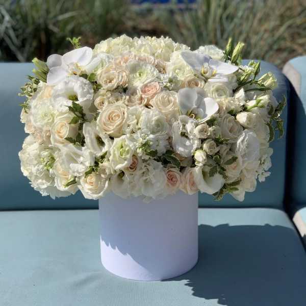 White and blush floral arrangement in a round white box