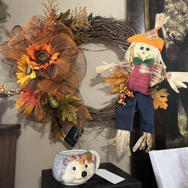 Fall wreath with sunflowers and a scarecrow decoration on a wall