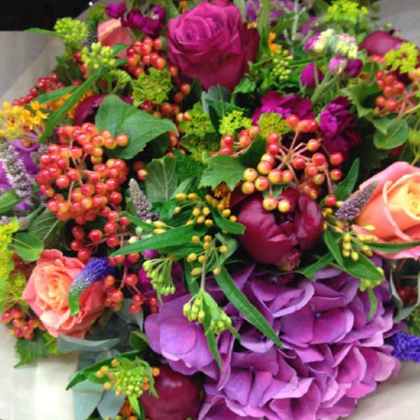 Bouquet of pink and purple flowers with berry accents