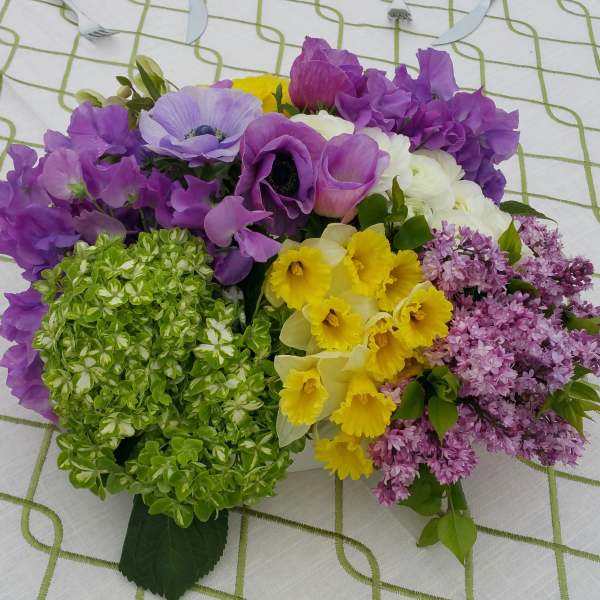 Bouquet of purple, yellow, white, and green flowers on a patterned cloth