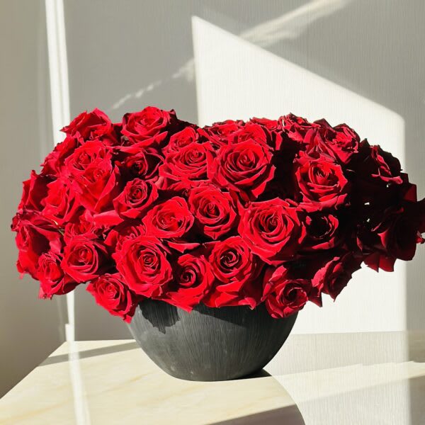 Red rose bouquet in a dark round vase