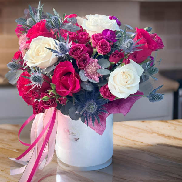 Bouquet of pink and white roses in a white hat box with ribbon