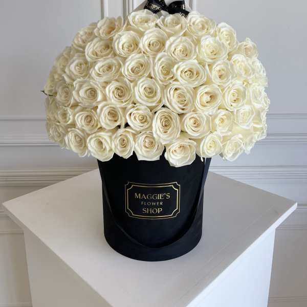 Large bouquet of white roses in a black hat box
