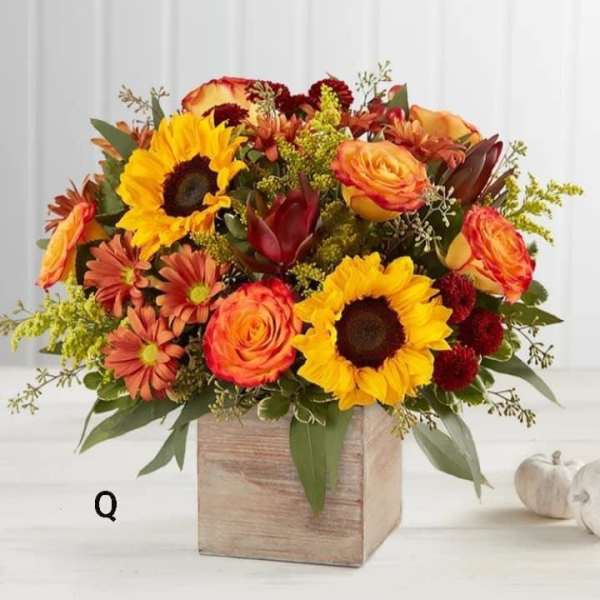 Mixed bouquet of sunflowers, roses, and mums in a wooden box