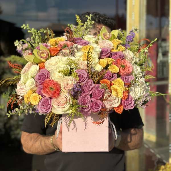 Large mixed bouquet of roses in a pink box