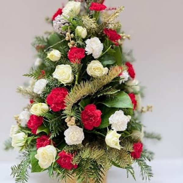 Cone-shaped floral arrangement with red and white blooms in a gold container