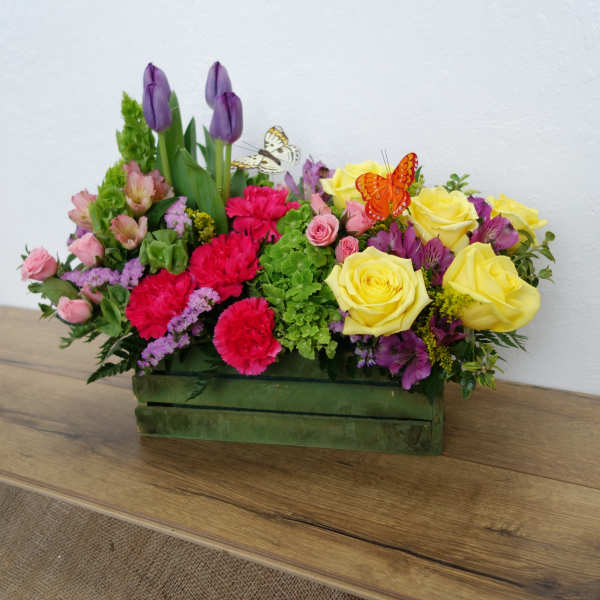 Mixed bouquet in a green rectangular box with yellow roses and purple tulips