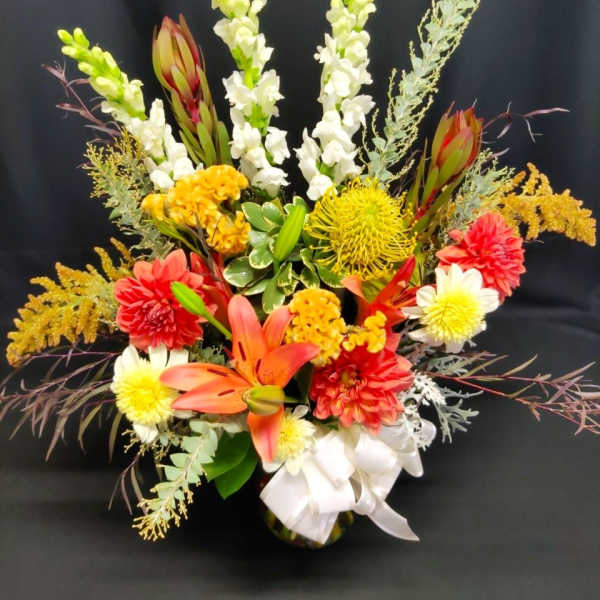 Colorful floral arrangement with lilies, snapdragons, and chrysanthemums in a vase