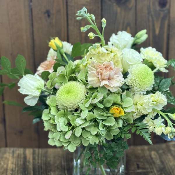 Bouquet of pale green and white flowers in a clear glass vase